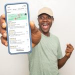 Smiling man showing phone with Google Map Pack