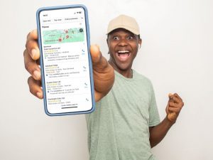 Smiling man showing phone with Google Map Pack