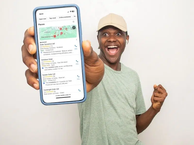 Smiling man showing phone with Google Map Pack