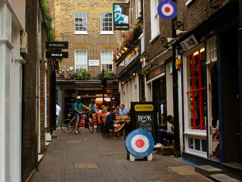 Narrow street of independent shops with hanging signs