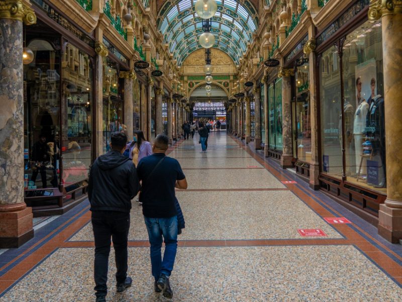 Shoppers walking through a Victorian covered shopping arcade