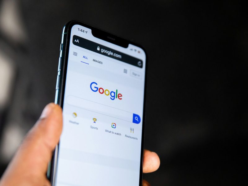 Hand holding a phone open on the Google search page