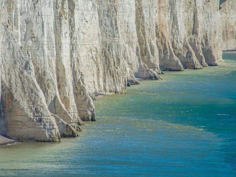 Chalk cliffs above turquoise water at low tide