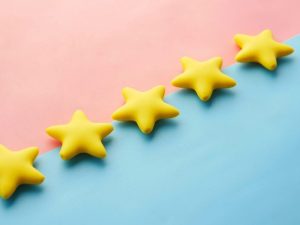 Row of yellow five-star shapes on a pink and blue background