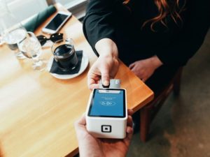 Customer paying by card on a card reader in a café