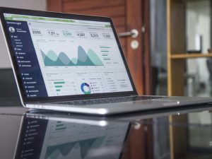 Laptop on a desk showing an analytics dashboard with charts
