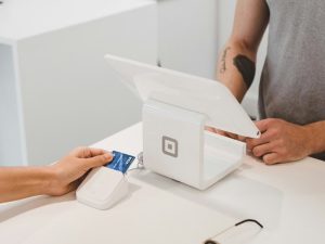 Card payment being made at a white countertop card reader