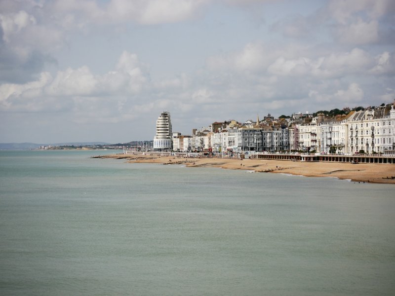 Seafront buildings and a beach seen across calm water
