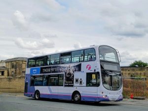 Double-decker bus with advertising on its side