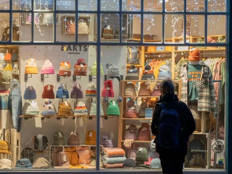 Customer looking into a lit shop window at night