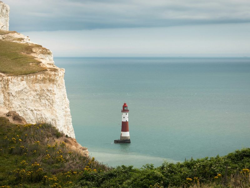 Lighthouse below white chalk cliffs on the Sussex coast