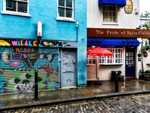 Brightly painted shops and a pub on a cobbled street