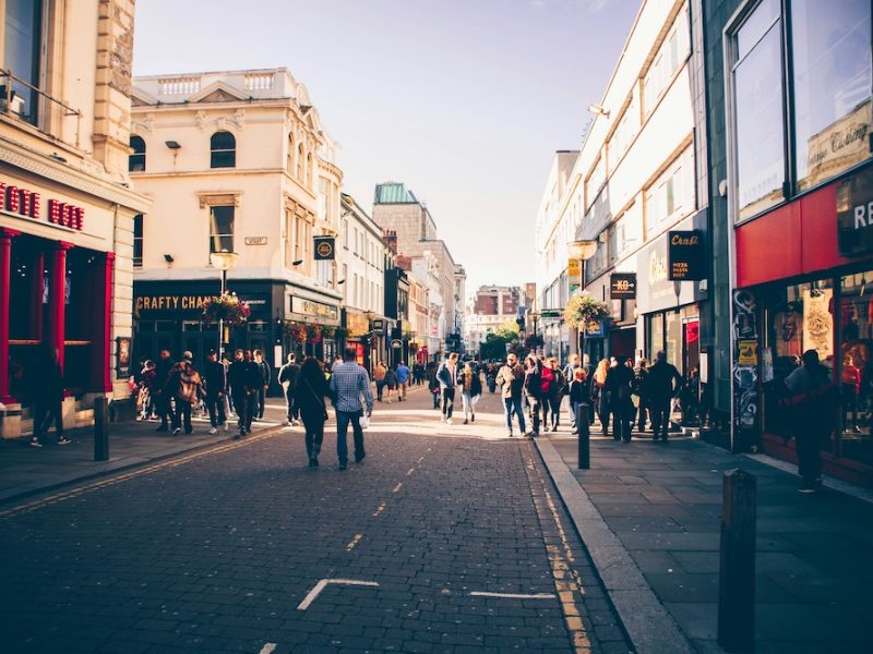 Busy UK high street with shoppers walking past shops